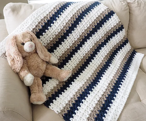crochet blanket on sofa along with a stuffed toy bunny