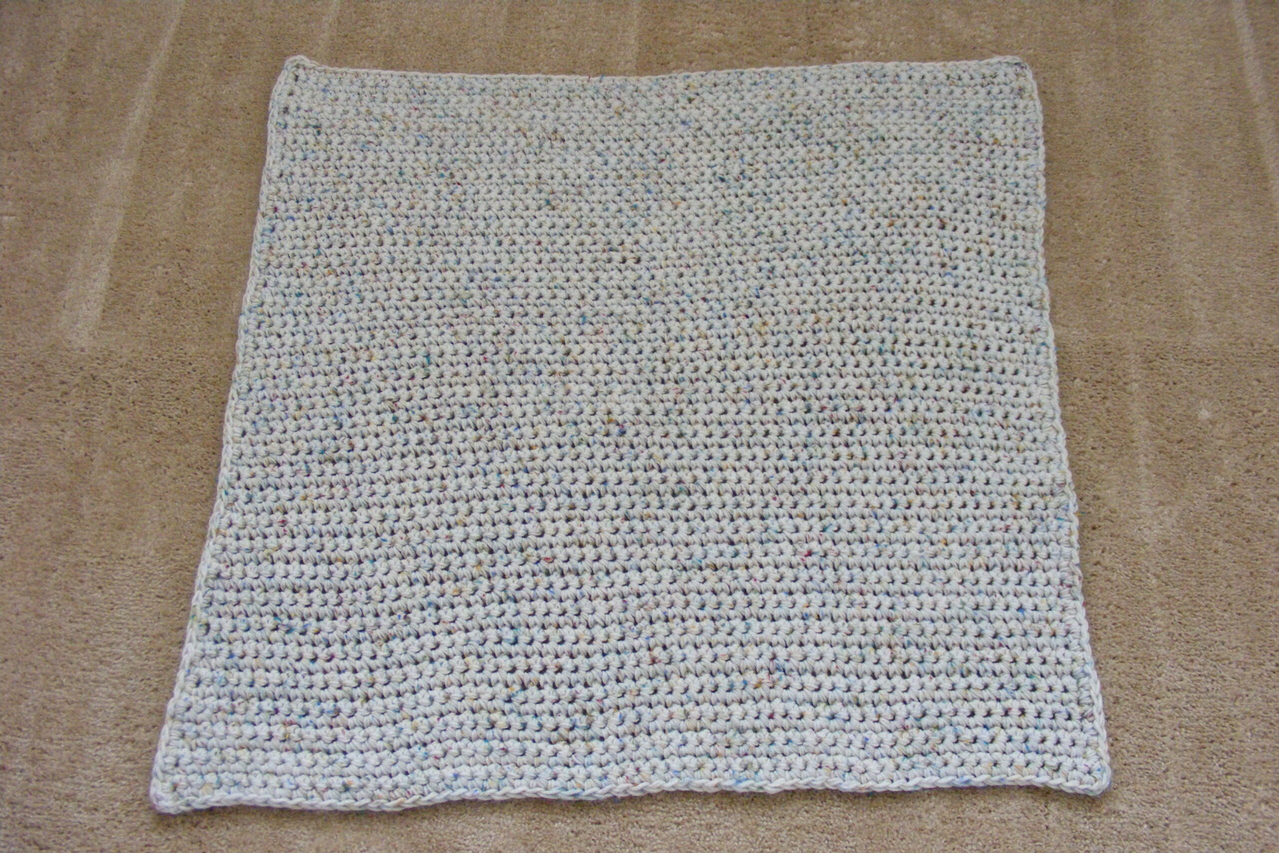 Single Crochet Baby Blanket laid on a carpeted floor